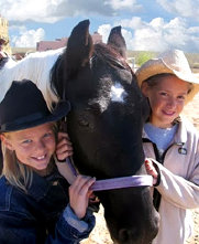 Girls hugging horse